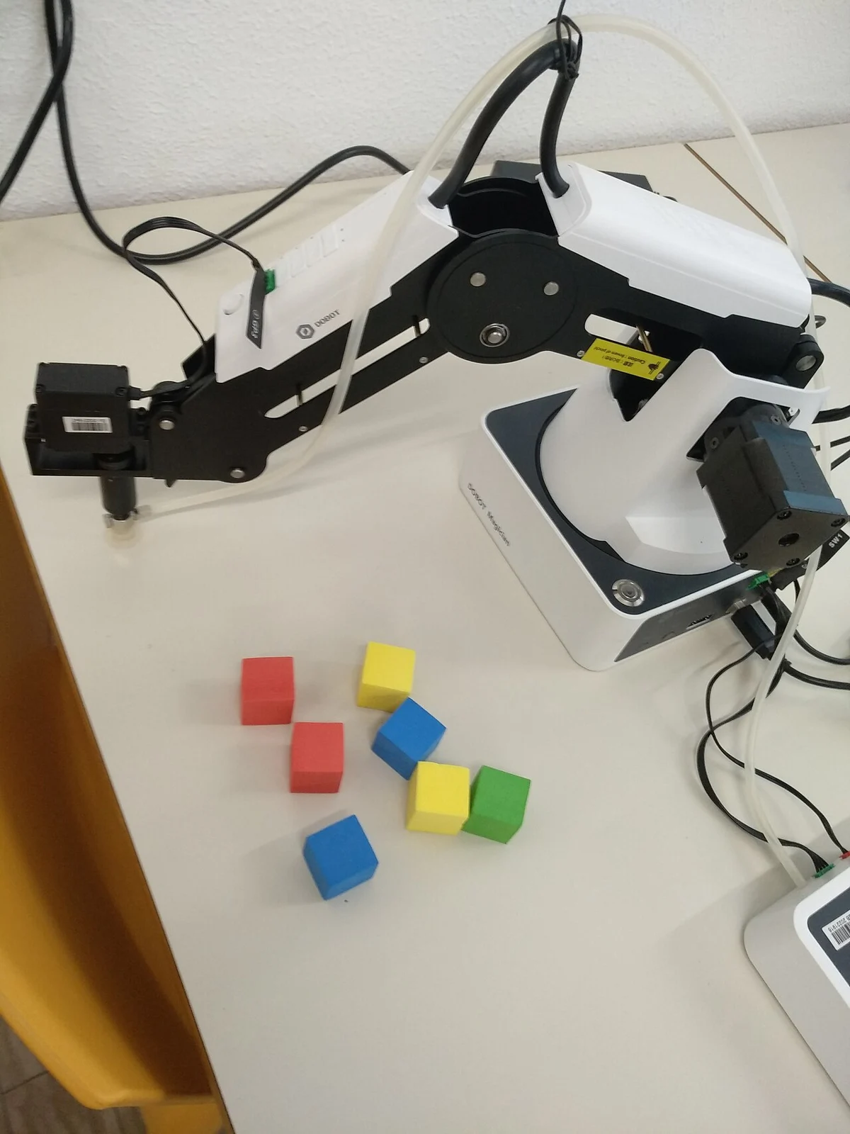 Dobot Magician arms manipulating colored blocks
